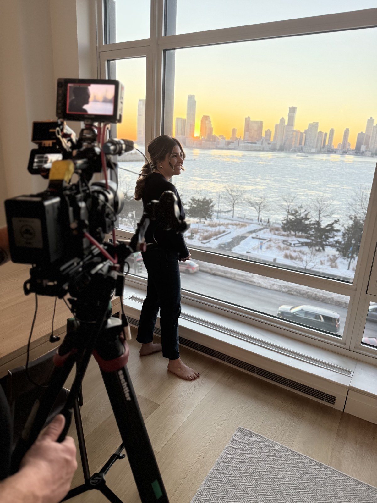Talent on camera against the Hudson River skyline at sunset